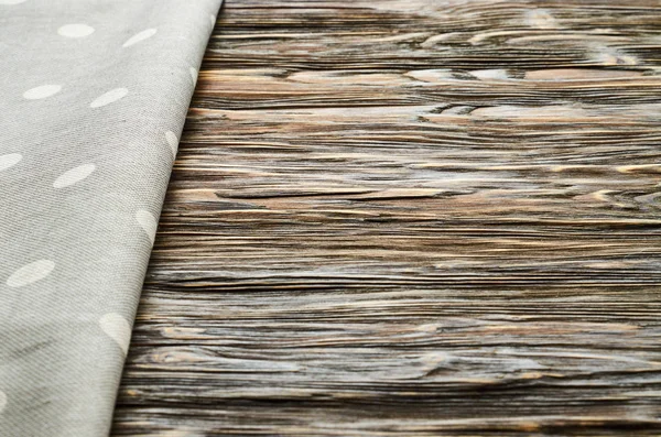 Old dark wooden background. Wooden table with grey kitchen towel