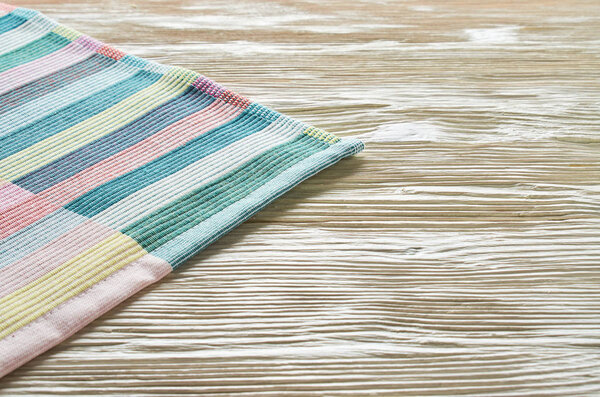 Old light wooden background. Wooden table with colored kitchen towel