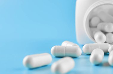 Pills tablet kapsülleri yakın çekim. Mavi bir arka plan, bir kavanoz ilaç..