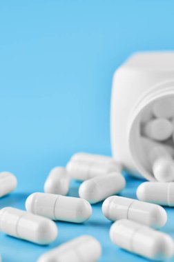 Pills tablet kapsülleri yakın çekim. Mavi bir arka plan, bir kavanoz ilaç..