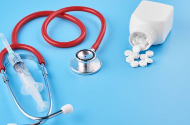 Pills tablet kapsülleri yakın çekim. Mavi bir arka plan, bir kavanoz ilaç. Mavi bir arka plan, bir kavanoz ilaç ve bir stetoskop..