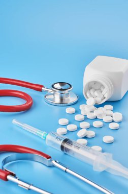 Pills tablet kapsülleri yakın çekim. Mavi bir arka plan, bir kavanoz ilaç. Mavi bir arka plan, bir kavanoz ilaç ve bir stetoskop..