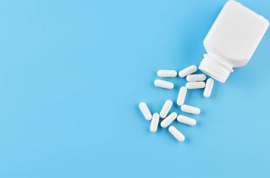 Pills tablet kapsülleri yakın çekim. Mavi bir arka plan, bir kavanoz ilaç..