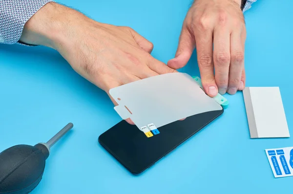 El hombre que reemplaza el protector de pantalla de vidrio templado roto para teléfono inteligente . — Foto de Stock