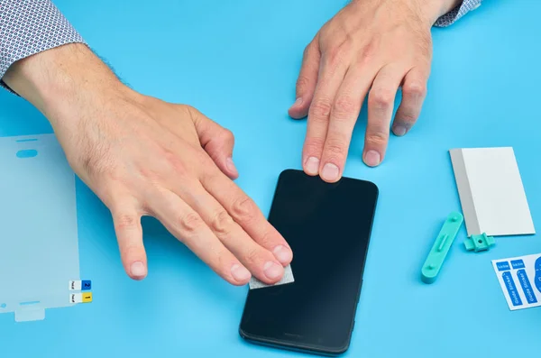 El hombre que reemplaza el protector de pantalla de vidrio templado roto para teléfono inteligente . — Foto de Stock