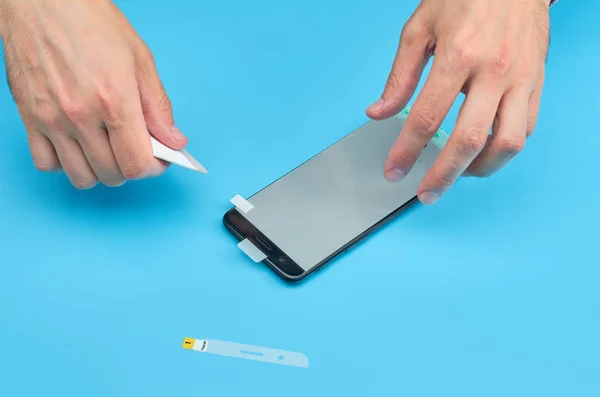 El hombre que reemplaza el protector de pantalla de vidrio templado roto para teléfono inteligente . — Foto de Stock