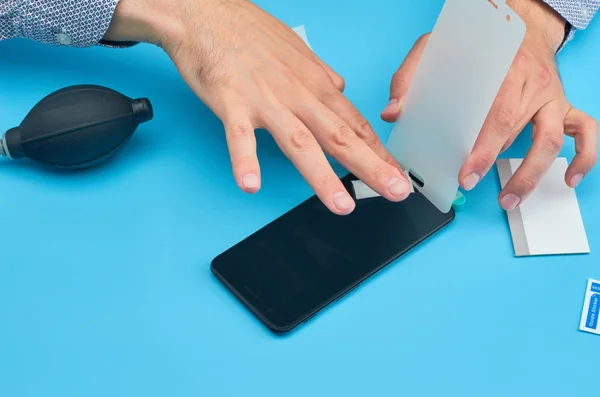 El hombre que reemplaza el protector de pantalla de vidrio templado roto para teléfono inteligente . — Foto de Stock