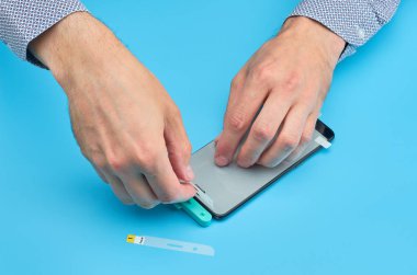 Akıllı telefon için kırık temperli cam ekran koruyucusu yerine adam.