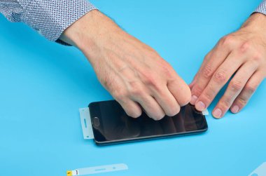 Akıllı telefon için kırık temperli cam ekran koruyucusu yerine adam.