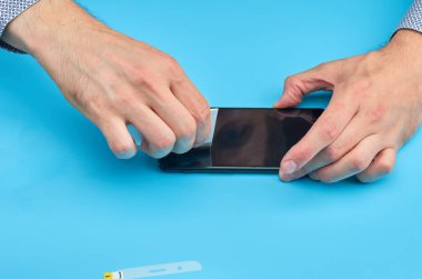 Akıllı telefon için kırık temperli cam ekran koruyucusu yerine adam.