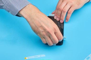 Akıllı telefon için kırık temperli cam ekran koruyucusu yerine adam.