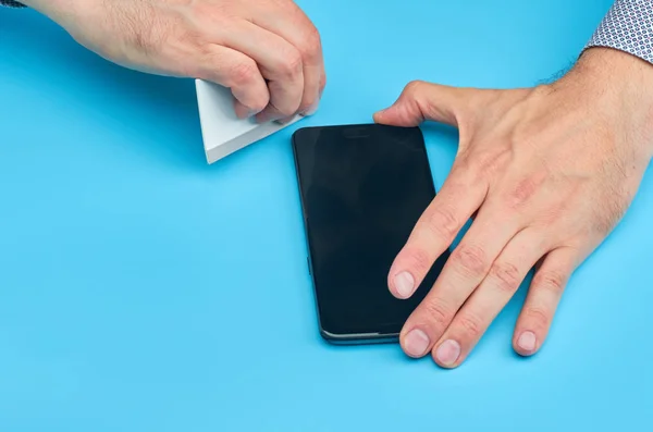 El hombre que reemplaza el protector de pantalla de vidrio templado roto para teléfono inteligente . — Foto de Stock