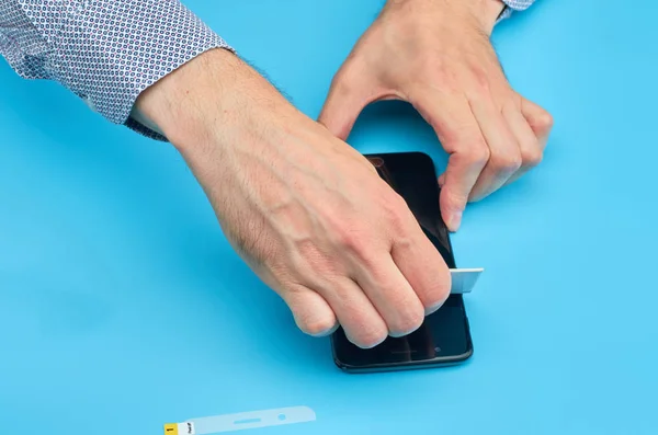 El hombre que reemplaza el protector de pantalla de vidrio templado roto para teléfono inteligente . — Foto de Stock