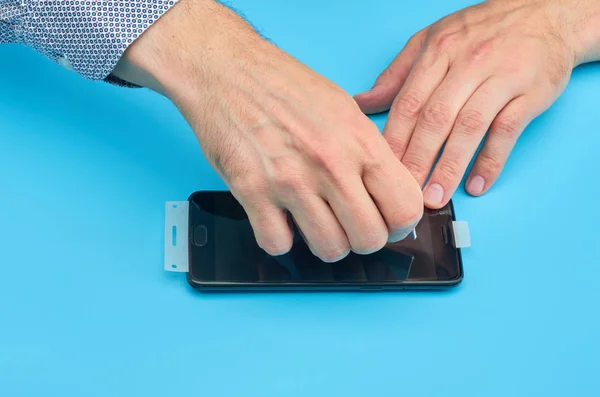 El hombre que reemplaza el protector de pantalla de vidrio templado roto para teléfono inteligente . — Foto de Stock