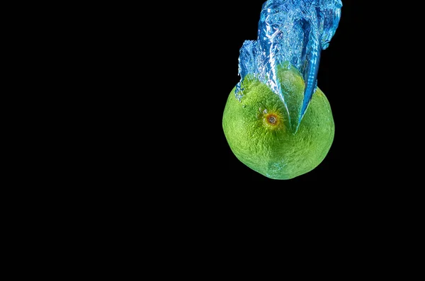 Siyah arka planda sıçrama ile suya düşen taze Lyme — Stok fotoğraf