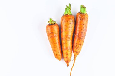 Beyaz arka planda izole edilmiş üç taze havuç. Yukarıdan manzara. Organik gıda arka plan.