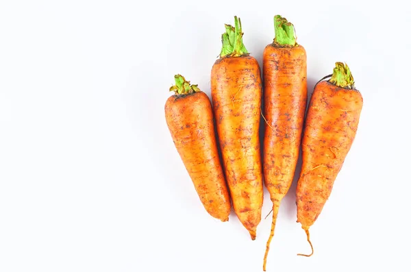 Cuatro zanahorias frescas aisladas sobre fondo blanco. La vista desde arriba. Fondo alimentario ecológico . —  Fotos de Stock