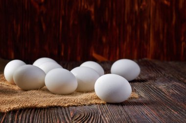 Köy masasında taze beyaz yumurtalar. Düşük anahtar.