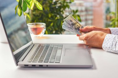 Pencereye karşı bir dizüstü bilgisayar erkek elleri.