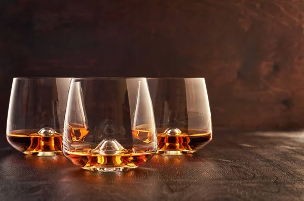 Bicchiere di cristallo con whisky su un tavolo di legno — Foto Stock