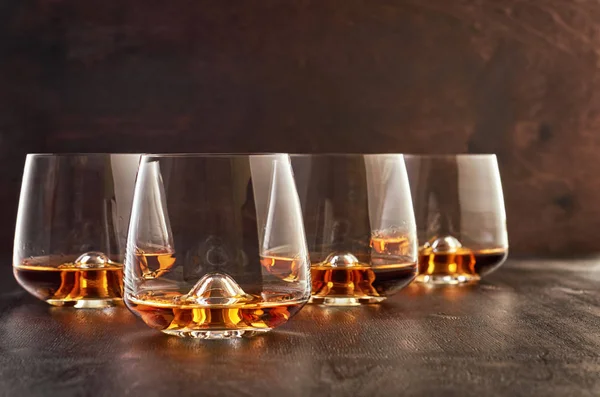 Bicchiere di cristallo con whisky su un tavolo di legno — Foto Stock