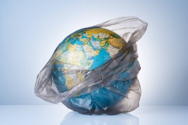 Dünyayı plastik atıklardan koruma kavramı, çevre kirliliğiyle mücadele, çevre için mücadele, açık arkaplanda siyah bir çöp torbasında bir dünya. Poşet yok..