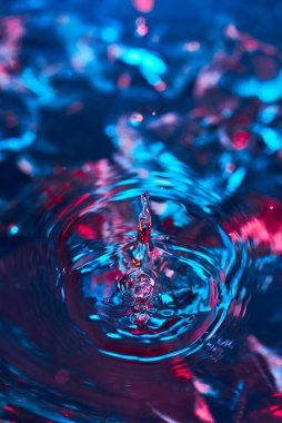 Kali 'den bir damla su, suyun üstünde daireler, soyut desenler, donmuş su sıçramaları. Soyut arkaplan.