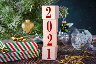 Kutularda hediyeler, Noel süslemeleri ve süslü ladin dalları olan 2021 numaralı küpler. Metin için boş alanı olan Noel arkaplanı.