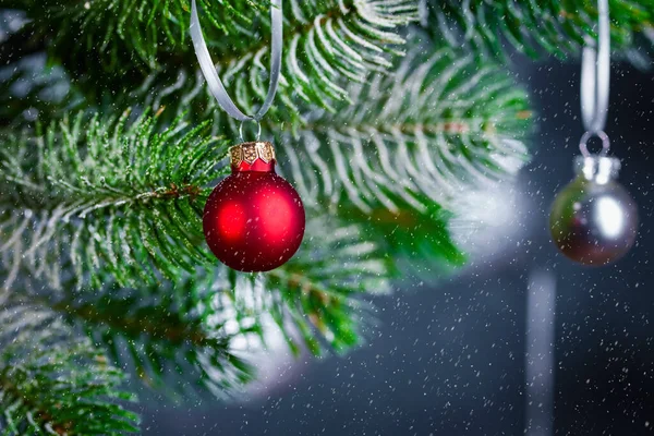 スプルースの枝 枝の上の赤いボール そして雪が降っているクリスマスの背景 テキストのためのフリースペースと新年の背景 — ストック写真