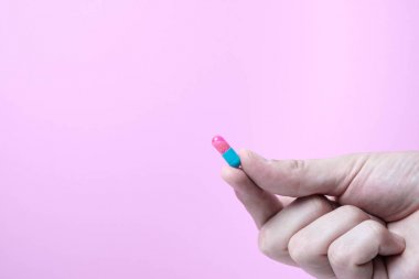 Pembe arka plan ile elinde Kapsül tıp