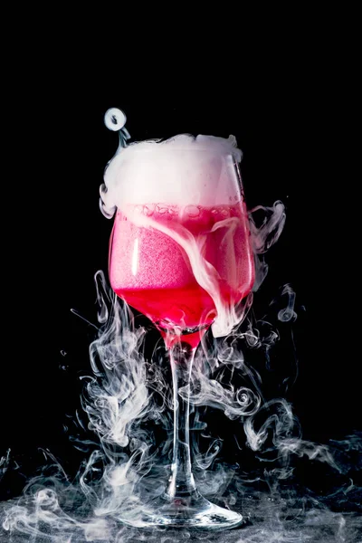 Glass with pink drink and dry ice smoke, bubbles, background