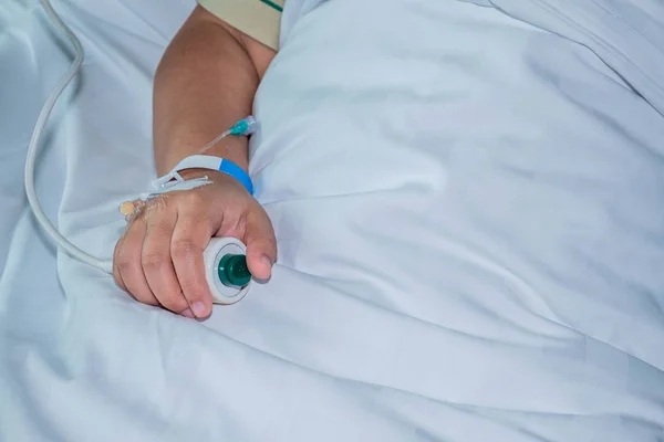 Пациент в больнице в постели с экстренной кнопкой — стоковое фото