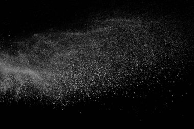 Siyah zemin üzerindeki beyaz parçacıkların hareketlerini dondur. Barut patlaması. Soyut toz tabakası dokusu.