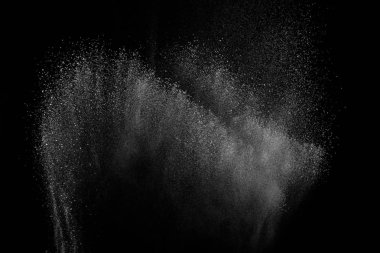 Siyah zemin üzerindeki beyaz parçacıkların hareketlerini dondur. Barut patlaması. Soyut toz tabakası dokusu.