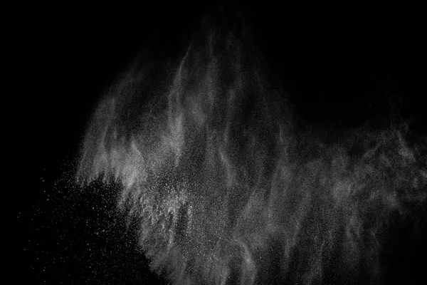 Siyah zemin üzerindeki beyaz parçacıkların hareketlerini dondur. Barut patlaması. Soyut toz tabakası dokusu.
