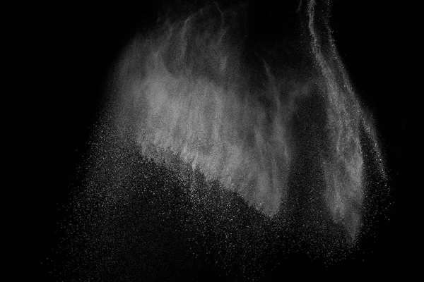 Siyah zemin üzerindeki beyaz parçacıkların hareketlerini dondur. Barut patlaması. Soyut toz tabakası dokusu.