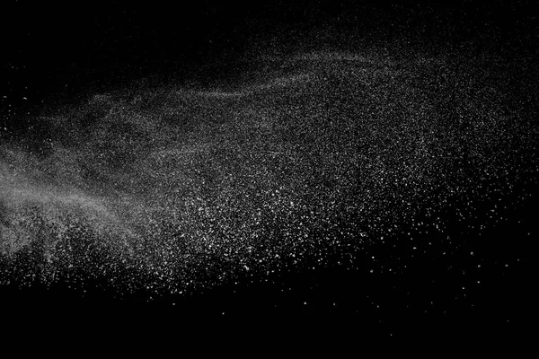 Siyah zemin üzerindeki beyaz parçacıkların hareketlerini dondur. Barut patlaması. Soyut toz tabakası dokusu.