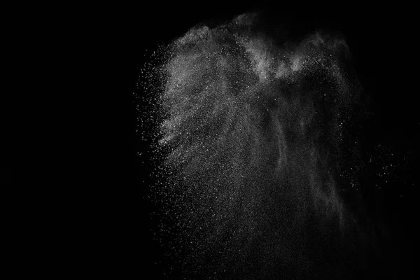 Siyah zemin üzerindeki beyaz parçacıkların hareketlerini dondur. Barut patlaması. Soyut toz tabakası dokusu.