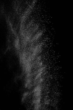 Siyah zemin üzerindeki beyaz parçacıkların hareketlerini dondur. Barut patlaması. Soyut toz tabakası dokusu.