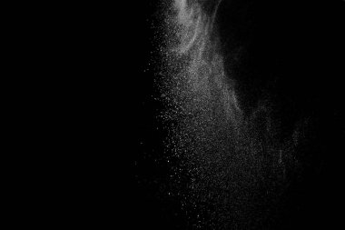 Siyah zemin üzerindeki beyaz parçacıkların hareketlerini dondur. Barut patlaması. Soyut toz tabakası dokusu.