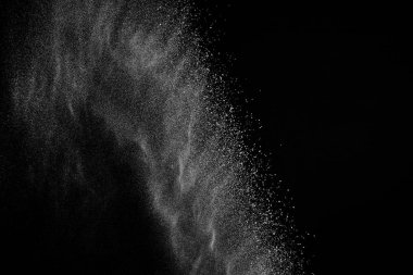 Siyah zemin üzerindeki beyaz parçacıkların hareketlerini dondur. Barut patlaması. Soyut toz tabakası dokusu.