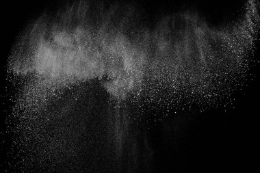Siyah zemin üzerindeki beyaz parçacıkların hareketlerini dondur. Barut patlaması. Soyut toz tabakası dokusu.
