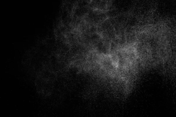 Siyah arka planda soyut su sıçramaları. Beyaz parçacıkların hareketlerini dondur. Yağmur, kar örtüsü dokusu.