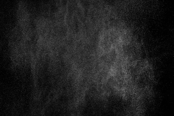 Siyah arka planda soyut su sıçramaları. Beyaz parçacıkların hareketlerini dondur. Yağmur, kar örtüsü dokusu.