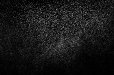 Siyah arka planda soyut su sıçramaları. Beyaz parçacıkların hareketlerini dondur. Yağmur, kar örtüsü dokusu.