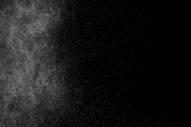 Siyah arka planda soyut su sıçramaları. Beyaz parçacıkların hareketlerini dondur. Yağmur, kar örtüsü dokusu.