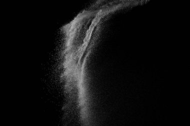 Siyah zemin üzerindeki beyaz parçacıkların hareketlerini dondur. Barut patlaması. Soyut toz tabakası dokusu.