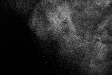 Siyah zemin üzerindeki beyaz parçacıkların hareketlerini dondur. Barut patlaması. Soyut toz tabakası dokusu.