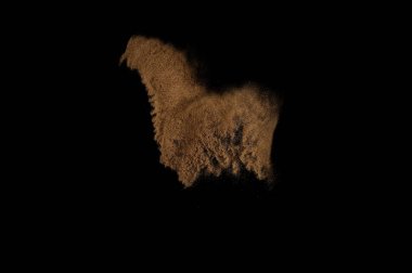 Kumsal patlaması siyah arka planda izole edildi. Soyut kum bulutu.