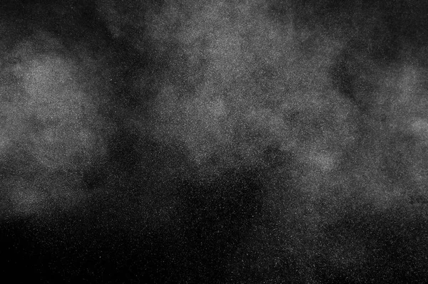 White powder explosion on black background. Abstract white dust texture.